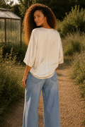 Polera Cubic V Satin marfil de mujer, vista posterior con Jeans Wide Leg Cuff Suede Belt